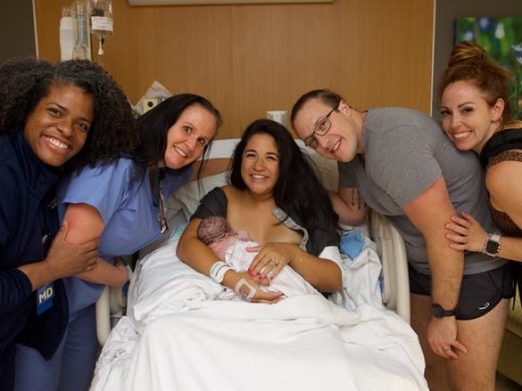 Nina (far right) supporting her client in the hospital shortly after birth.