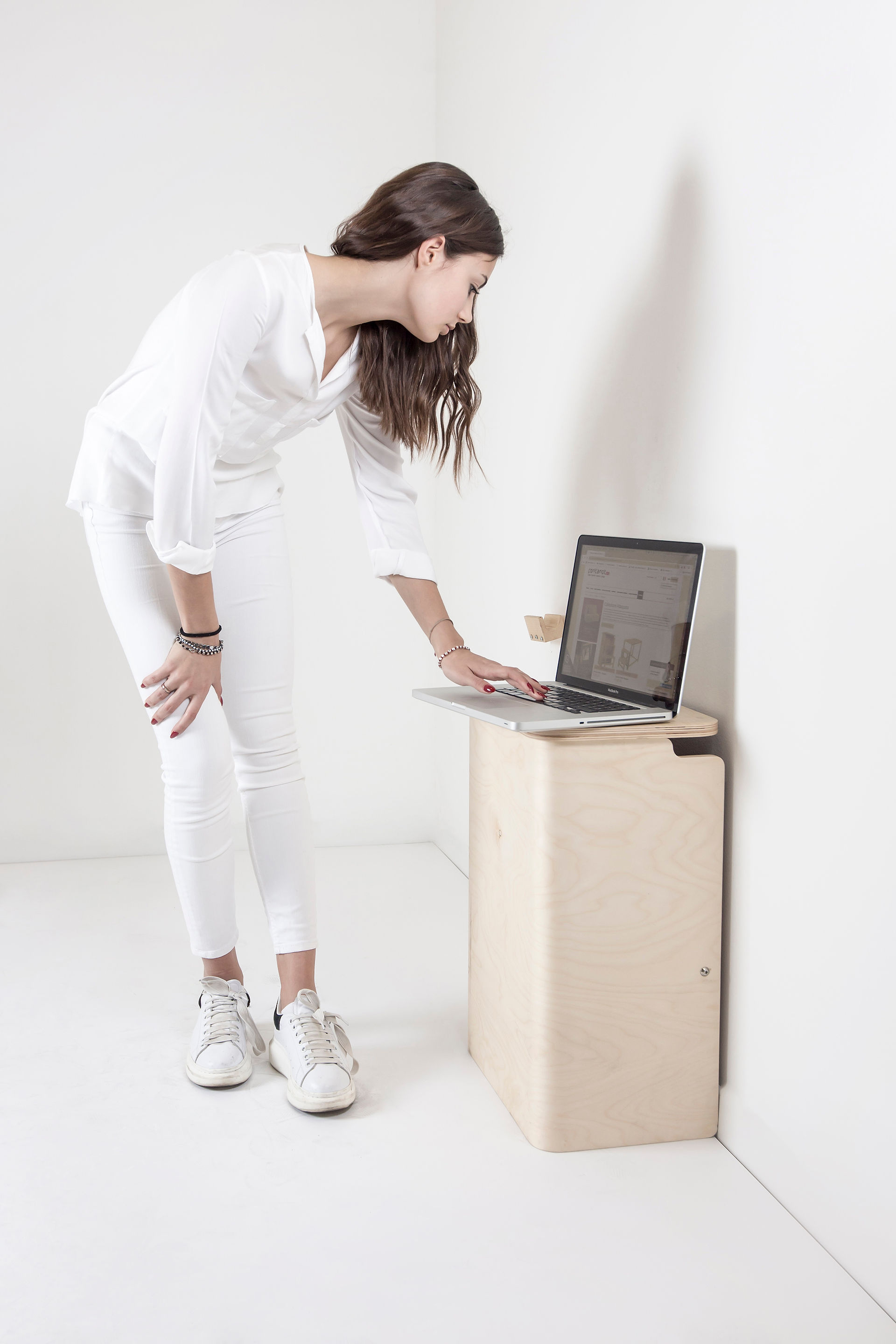 Donna che lavora al laptop su un piccolo tavolino scaletta