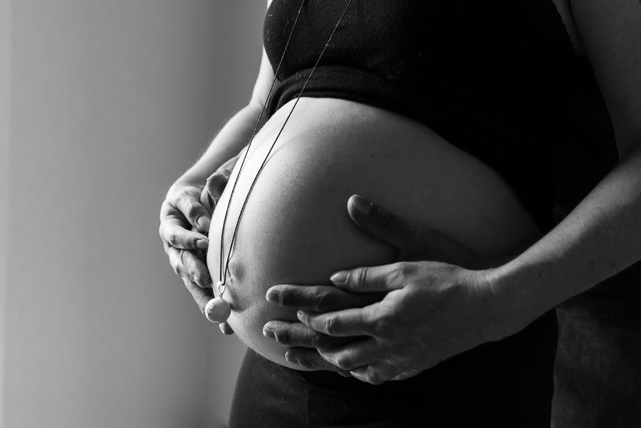 joli ventre de femme enceinte, avec les mains de maman et papa