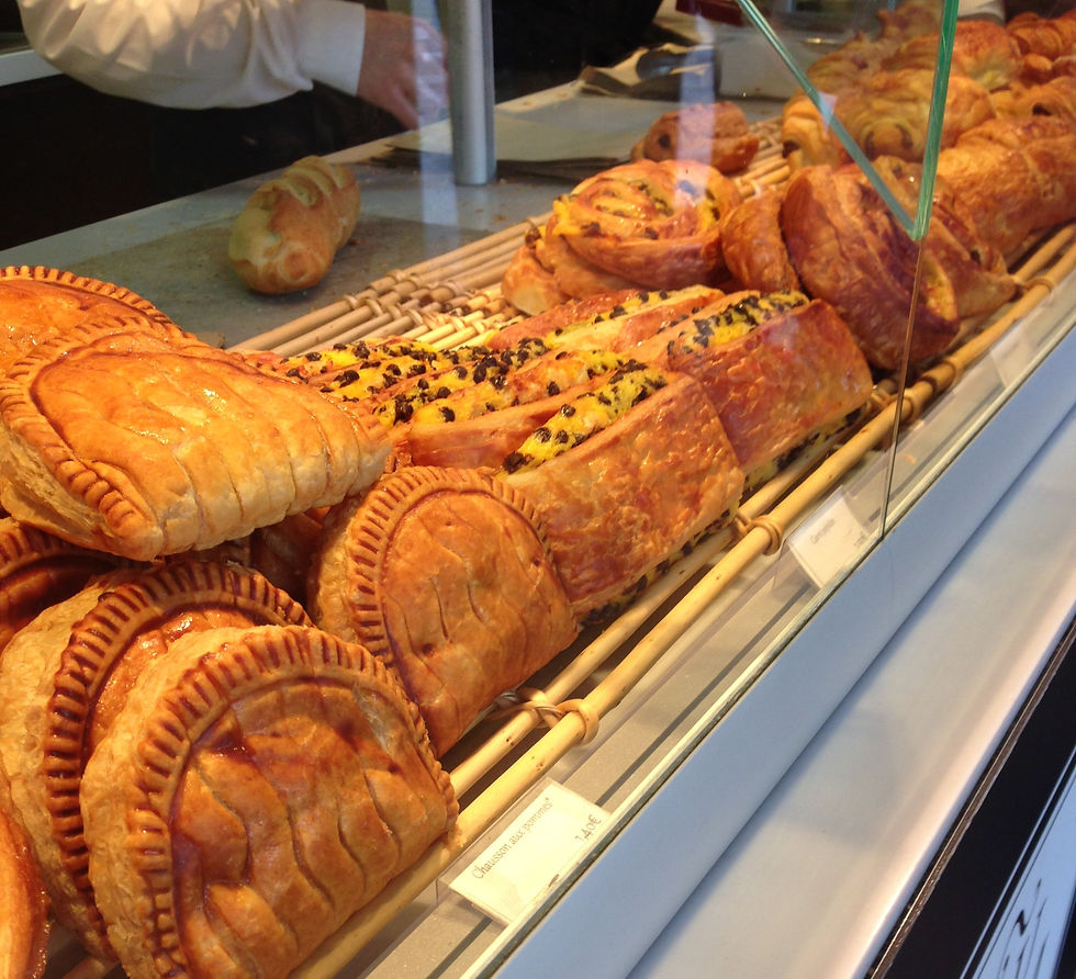 Pastries sitting in a window display at a bakery in Paris