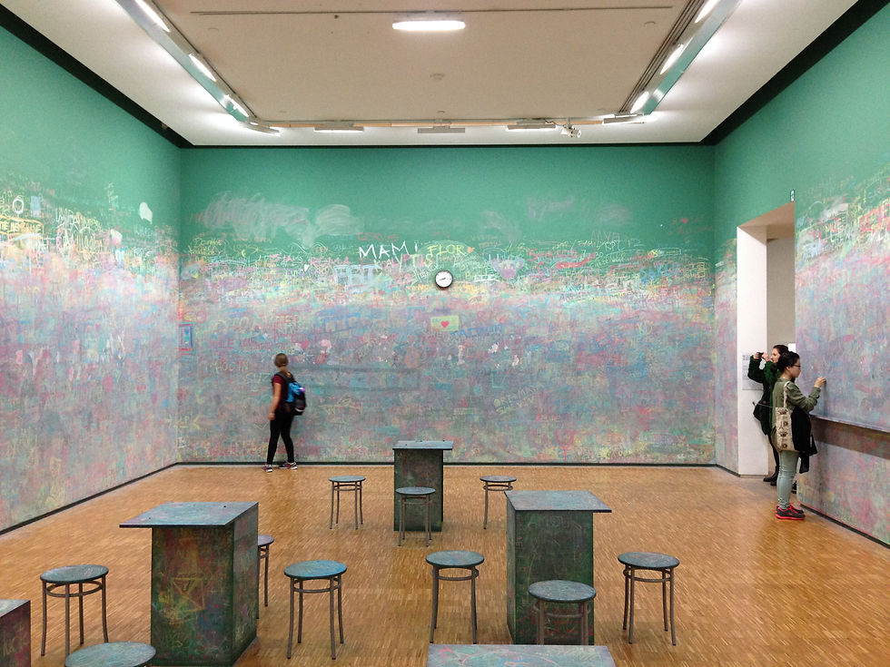 Tas participating in a live exhibition at Centre Pompidou by drawing with chalk on a wall
