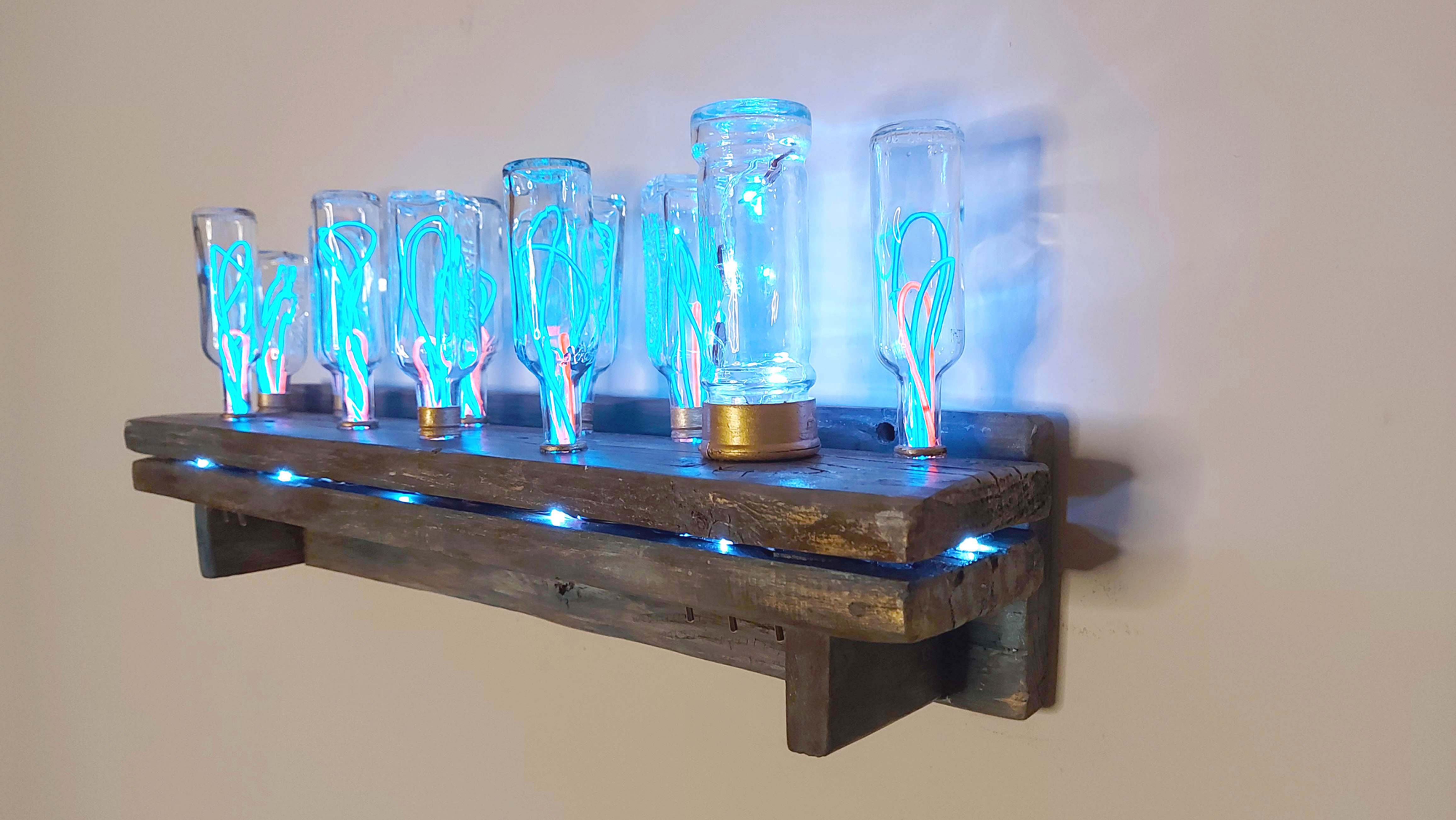 A unique, illuminated art piece featuring glass tubes with blue and red neon-like filaments.Tubes are mounded on a wood shelf