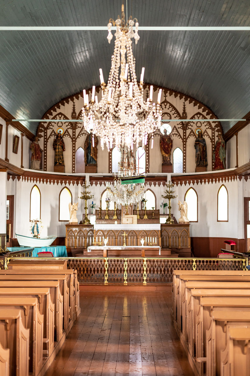 Majestic interior of the church of Île aux Marins, Saint-Pierre-et-Miquelon, with its wooden architecture, stained glass windows and atmosphere steeped in history and spirituality.