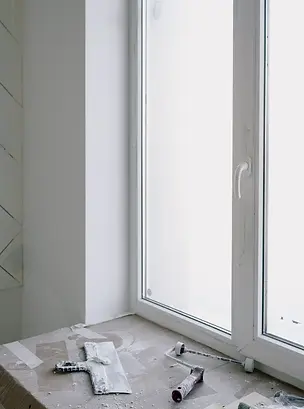 A windowframe with painting tools included from construction.