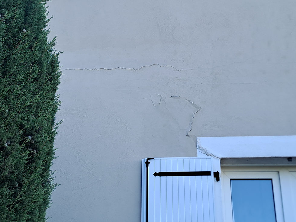 Fissure sur le mur d'une maison près d'une fenêtre, causée par le retrait-gonflement des argiles