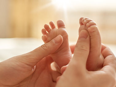 mum-making-baby-massage-mother-massaging-infant-bare-foot-preventive-massage-newborn-mommy