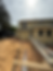 Yellow house under construction with dirt and building materials