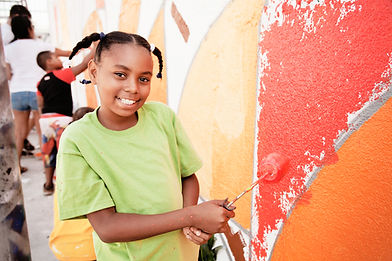 Smiling girl painting a wall.