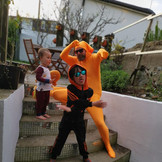 a parent in all orange clothes with 2 children on steps