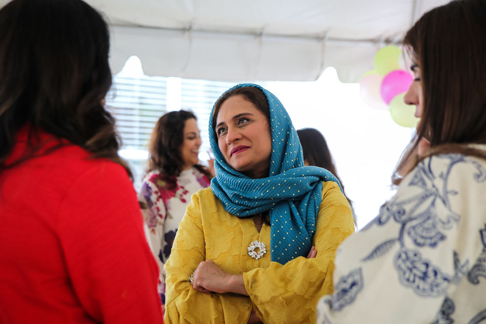 Candid image of a woman in a colorful head scarf at an Indian brunch event