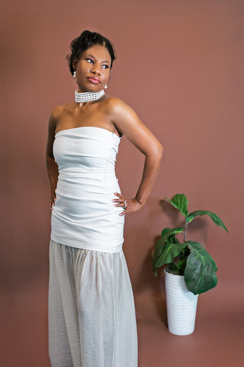 A woman poses for model-like birthday portraits in front of a backdrop