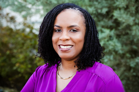A woman poses for a headshot outdoors
