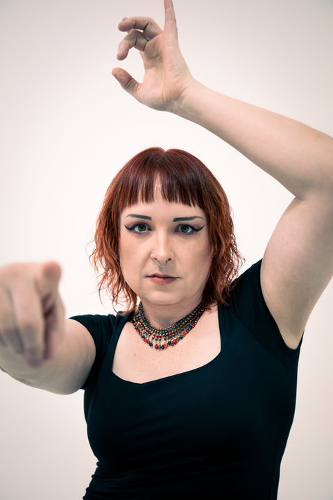 A woman poses for a photo in a studio