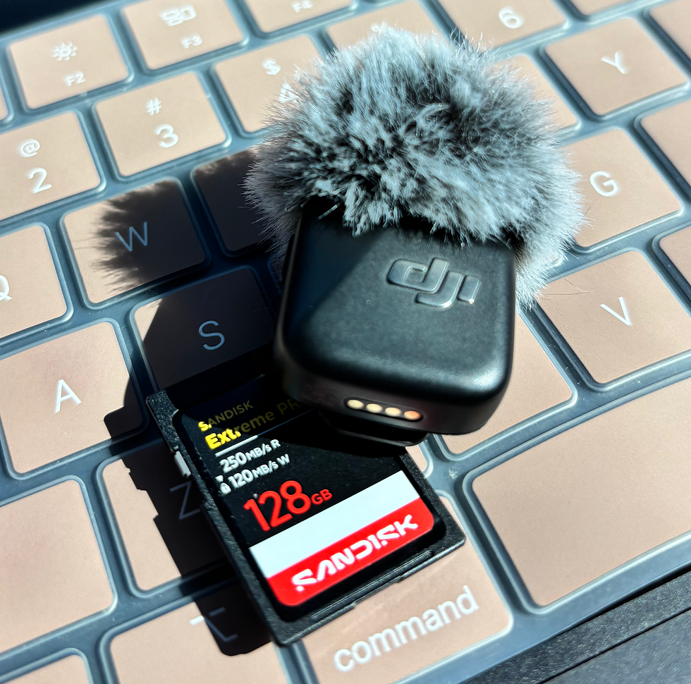 DJI wireless microphone with windscreen and SanDisk SD card on a laptop keyboard