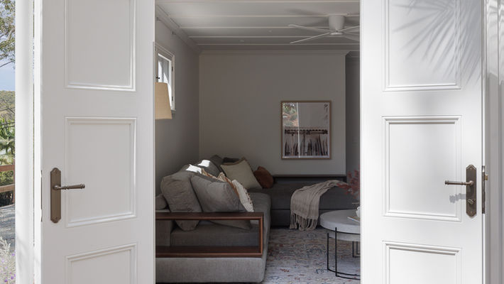 Open white French doors leading into a cozy NEST room.