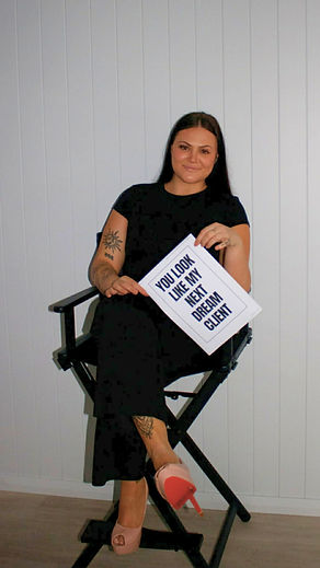 Jorja Harris holding 'YOU LOOK LIKE MY NEXT DREAM CLIENT' sign