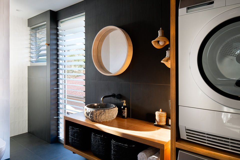 Swell at blueys Modern bathroom with round mirror, sink, and washing machine
