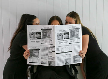 Three women looking at a newspaper