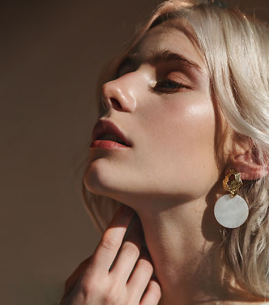 Blonde woman with a round earring in warm light