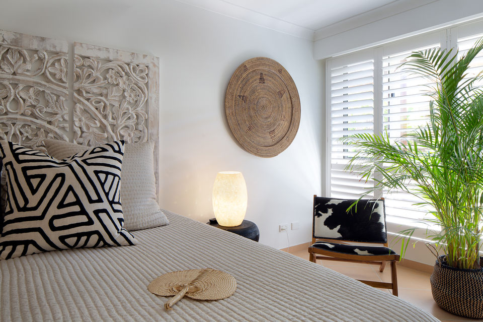 Bedroom with a bed, pillow, and decorative elements; white walls and natural light.