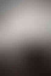 A kitchen featuring timeless white countertops and cabinetry with a dark navy blue island and wooden bar stools.