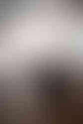 A kitchen featuring timeless white countertops and cabinetry with a dark navy blue island and wooden bar stools.