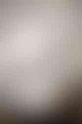 A kitchen featuring timeless white countertops and cabinetry with a dark navy blue island.