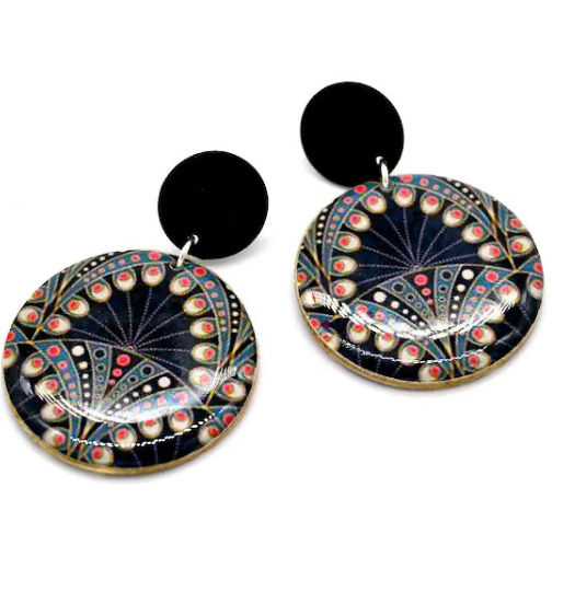 Boucles d'oreilles rondes en résine avec un motif de peacock coloré sur fond noir, attachées à des fermoirs noirs.