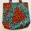 Miniature : Tote bag en wax africain, orné de motifs de grandes feuilles rouges et noires sur un fond turquoise avec des taches blanches.