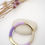 Miniature : Deux bracelets superposés, l'un en résine lavande et l'autre en ivoire, chacun avec des accents en métal doré, portés au poig