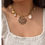 Miniature : Collier en perles blanches avec pendentifs en véritables coquillages, en acier inoxydable. Élégance et naturel réunis, parfai