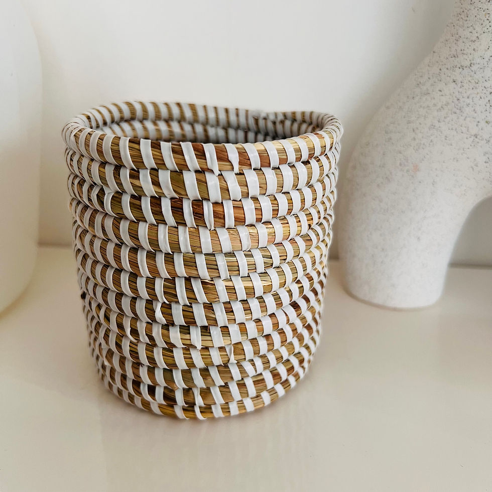 petit panier tissé rempli de stylos, utilisé comme organisateur de bureau, dans des tons naturels et blanc.