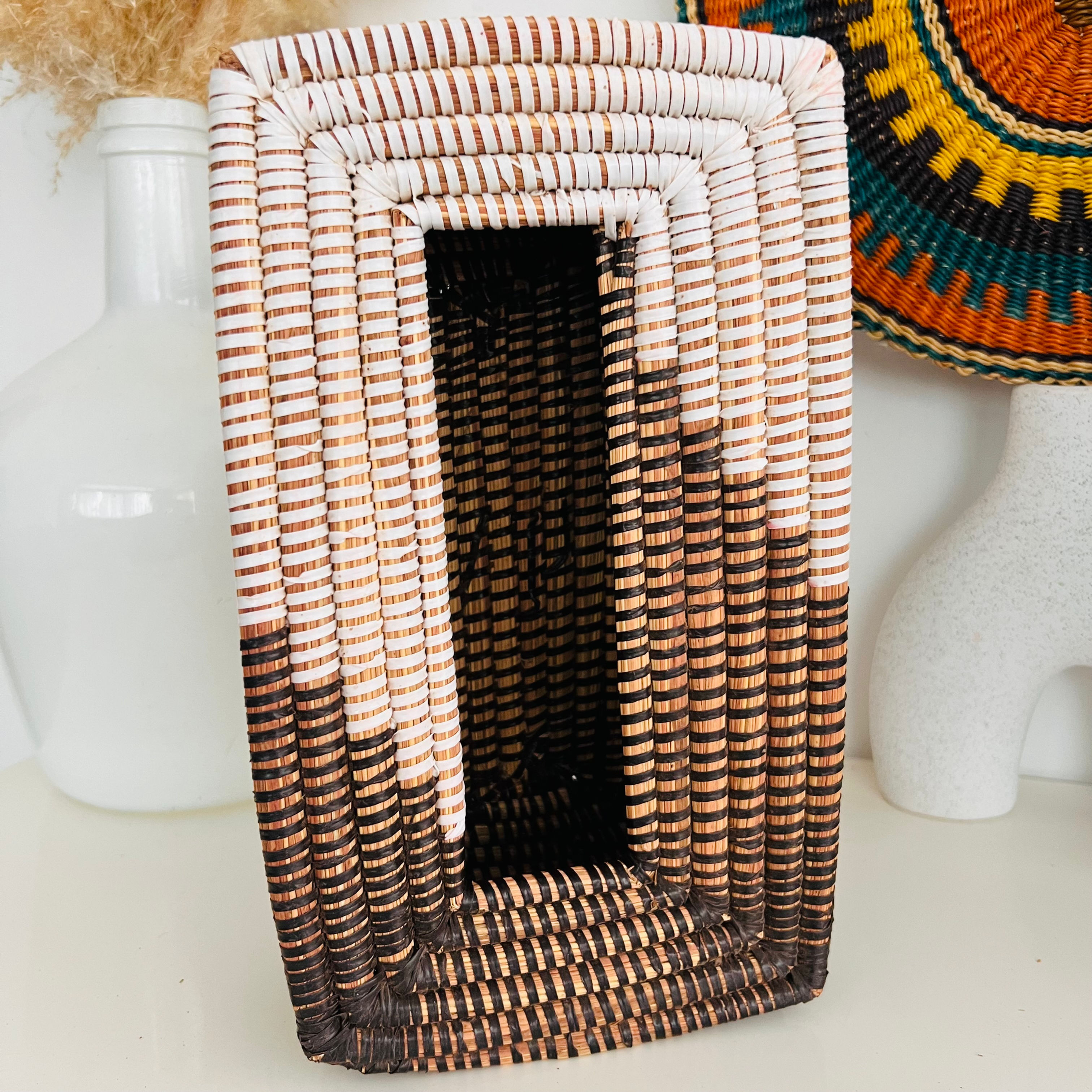 Boîte à mouchoirs verticale en osier de couleur naturelle avec motifs marron et blanc, vue de face avec un fond de décor