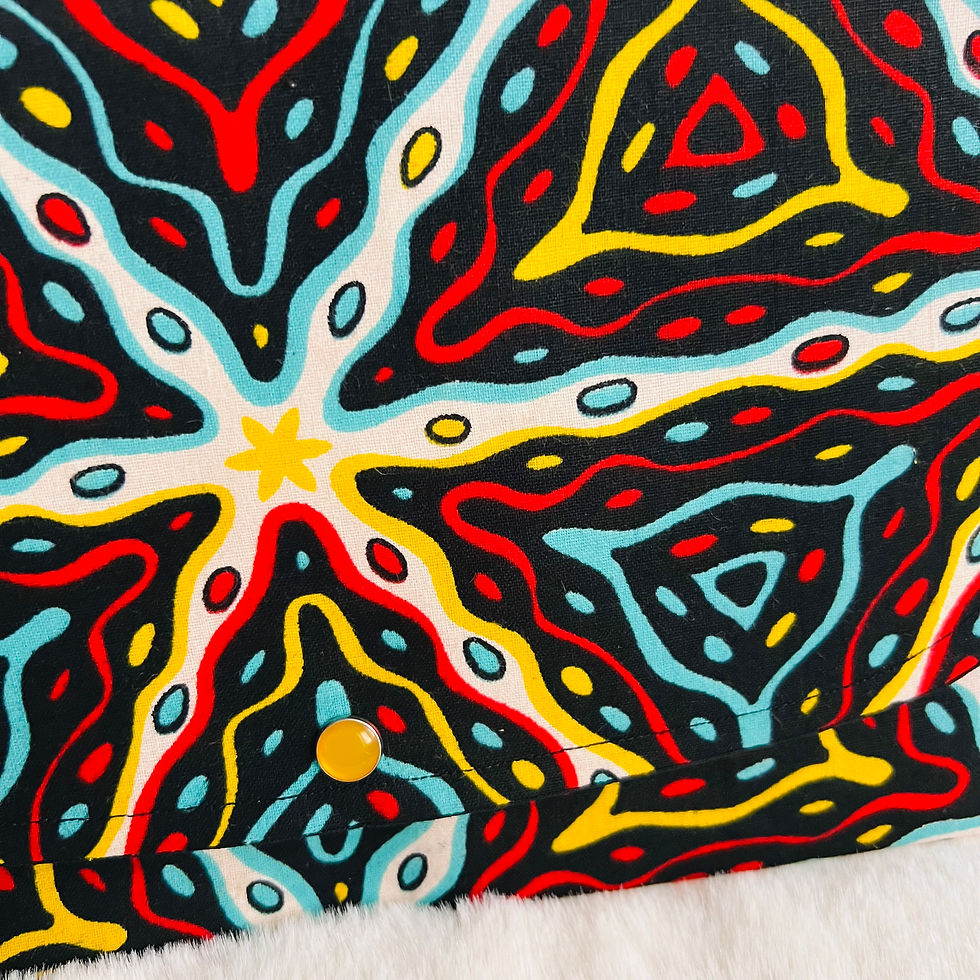 Pochette à main en wax multicolore avec motifs géométriques, fermée par bouton pression