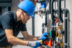 man-installs-heating-system-house-checks-pipes-with-wrench