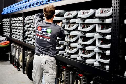 Coast 2 Coast Restorations worker in warehouse preparing air movers for water damage restoration in Central Florida 