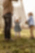 lustiges Familien-Fotoshooting mit kleinen Kindern die mit den Eltern mit einer Decke verstecken spielen