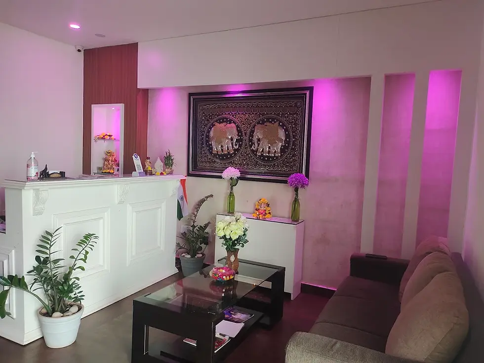 spa reception interior with pink ambient lighting, white counter, plants, and sofa