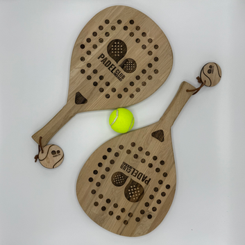 Twee houten padelrackets, door KRABER gefreesd en voorzien van een gravering met logo. Ambachtelijk maatwerk in hout, geschikt als decoratieve plank of als uniek serveerplank. Is op maat te bestellen met logo en ontwerp naar keuze.
