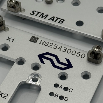 Een blank geanodiseerd frontpaneel waarop door KRABER serienummers en qr-codes gegraveerd zijn. Zwarte gravering op blank geanodiseerd aluminium.