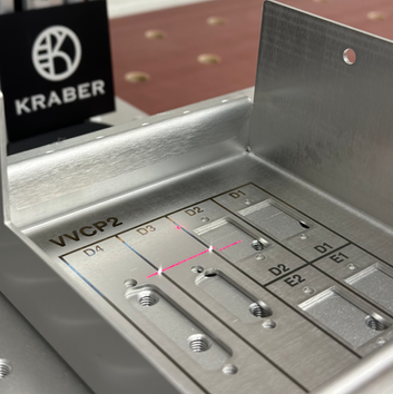 Een RVS mechatronica kast die door KRABER wordt voorzien van een zwarte lasermarkering. Heet onderdeel wordt aan meerdere kanten voorzien van lasermarkeringen.