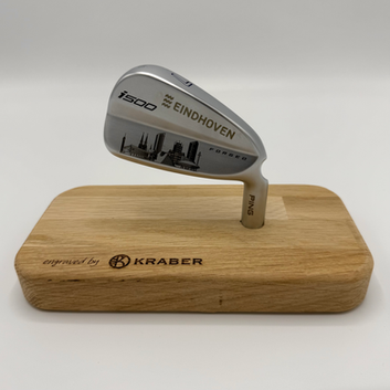 Een door KRABER gegraveerde golfclub op een houten plankje om de golfclub mooi tentoon te stellen. De golfclub is door KRABER voorzien van een gravering met de skyline van de stad Eindhoven en het logo van de stad Eindhoven.