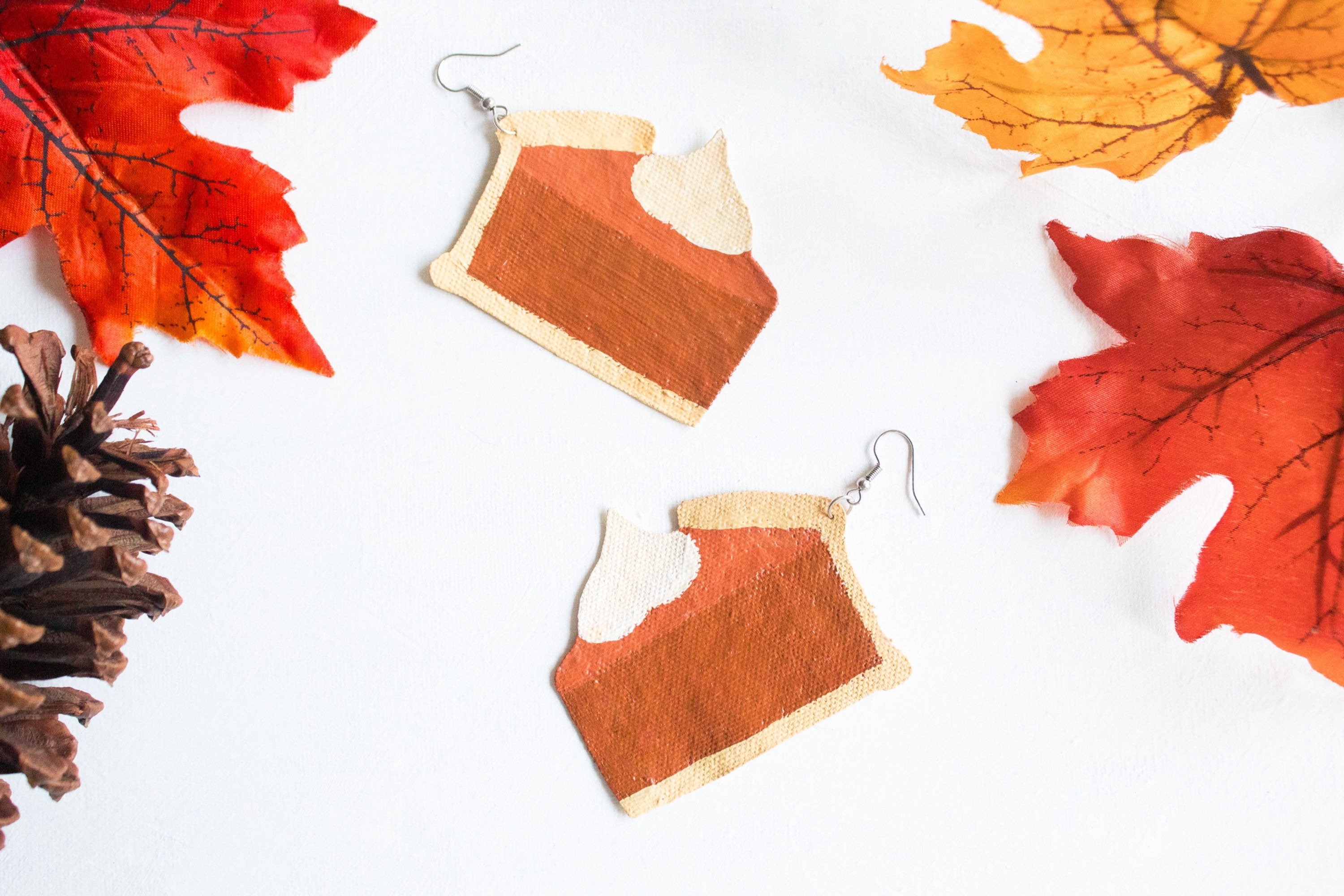 burnt orange and beige autumn, fall season earrings of pumpkin pie slices with whipped cream on top
