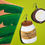 Thumbnail: Handmade statement earrings of a coconut oil jar and a coconut fruit with a brown and green palm tree earring holder