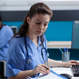 nurse doing digital work NHS blue scrubs