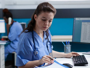 nurse doing digital work NHS blue scrubs