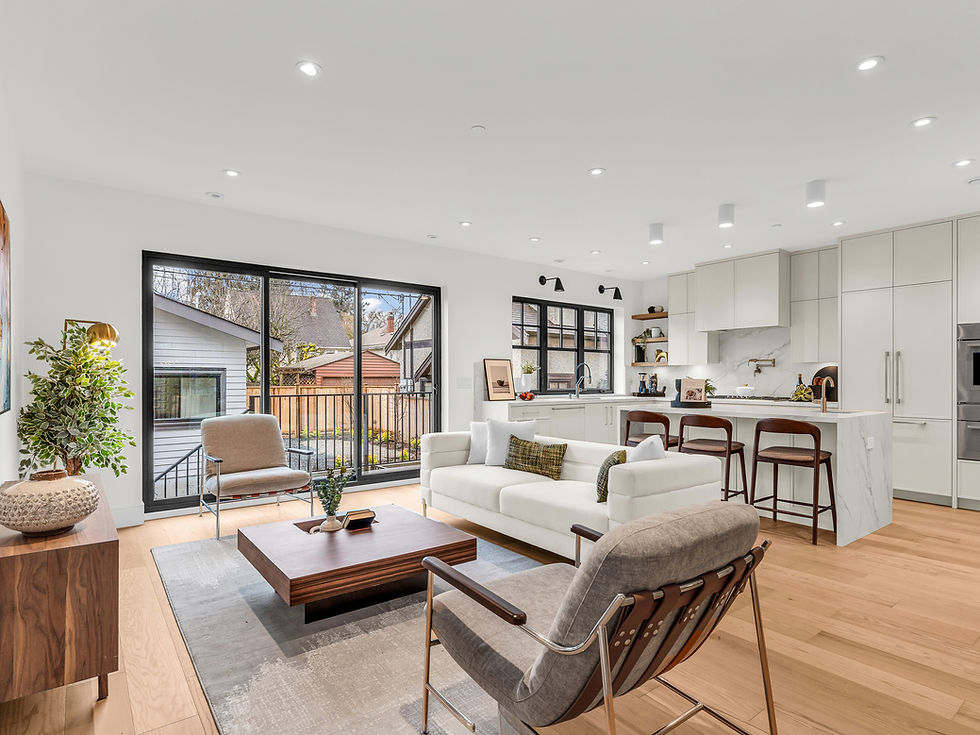 Cost to build a home vancouver. Custom home renovations. Bright modern open-plan living room and kitchen with white sofa, chairs, wood table, island stools, large windows, and potted plant