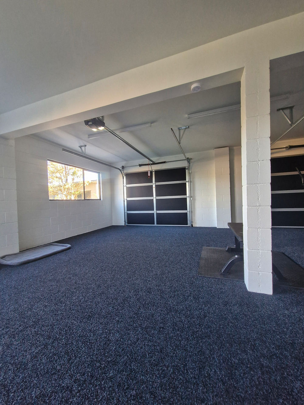 Modern renovated garage with dark epoxy flooring.
