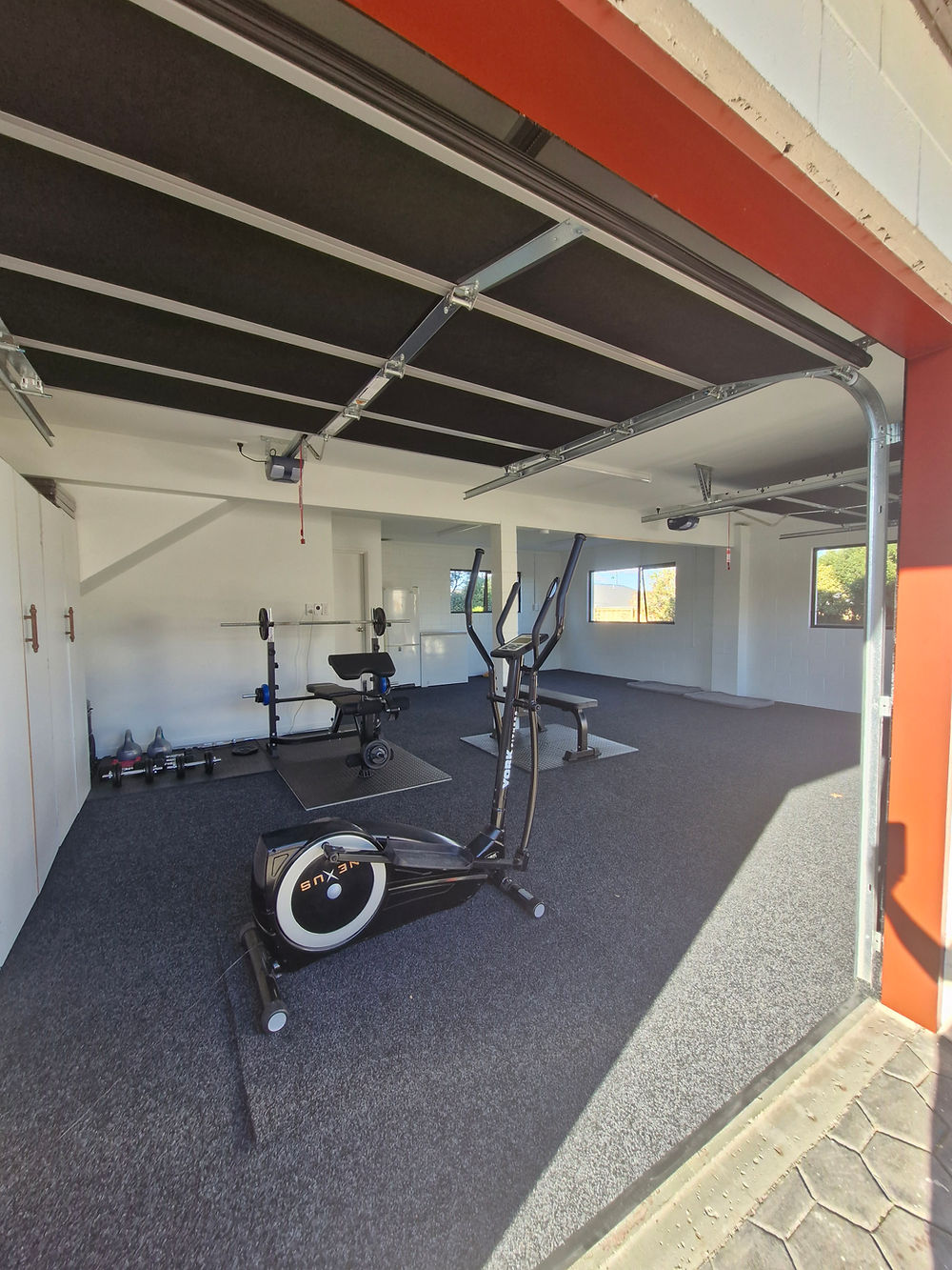 Home gym garage renovation with elliptical and weights