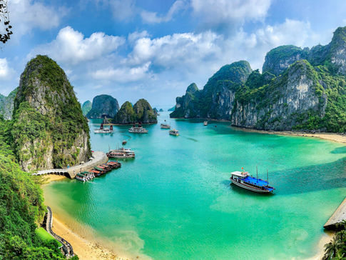 Large rocky mountains jut from the turquoise waters of Ha Long Bay, Vietnam.